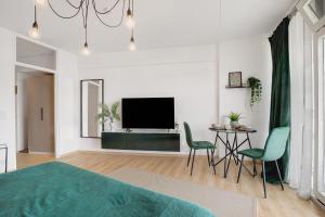 a bedroom with a television and a table and chairs at Global Bnb - Loft 28 Green in Augsburg