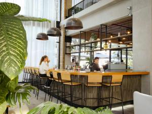 two people sitting at a bar in a restaurant at Mutuo Vive in Guadalajara