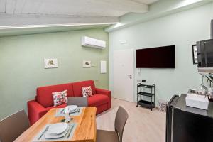 a living room with a red couch and a table at Residenza Borgo Antico Lucia in Ascea