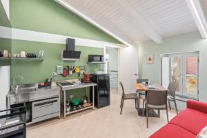 a kitchen and dining room with a red couch and a table at Residenza Borgo Antico Lucia in Ascea