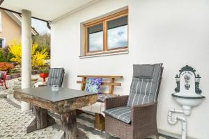 a patio with two chairs and a table at Bauzinger Alm in Hauzenberg +17 photos