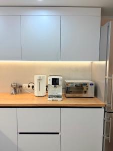 a kitchen with white cabinets and appliances on a counter at Новый Хостел с Кабинками in Chişinău