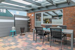 a patio with a table and chairs on it at Ferienhaus Ongi in Friedrichskoog-Spitze