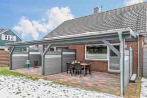 a pergola on a brick house with a table at Ferienhaus Ongi in Friedrichskoog-Spitze