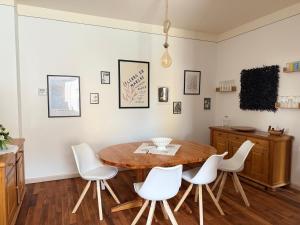 a dining room with a wooden table and white chairs at Appartement Neunkirchen City in Neunkirchen