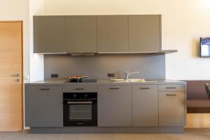 a kitchen with a sink and a stove at Daimlhof Ferienwohnung Moosherz in Völs am Schlern