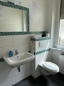 a bathroom with a sink and a toilet at Appartement Neunkirchen City in Neunkirchen +17 photos