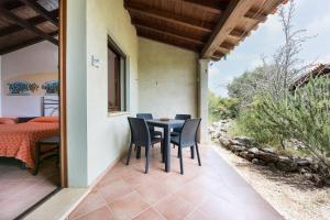 a room with a table and chairs on a patio at Su Birde Agriturismo in Orosei