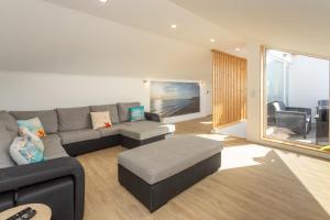 a living room with a couch and a table at Refúgio Das Barcas in Lourinhã