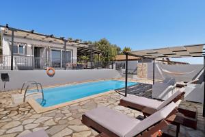 ein Schwimmbad mit Hängematte und ein Haus in der Unterkunft Villa Jimmy's Katomeri 2 in Meganisi