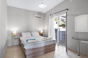ein weißes Schlafzimmer mit Bett und Badezimmer in der Unterkunft Villa Jimmy's Katomeri 2 in Meganisi + 20 Fotos