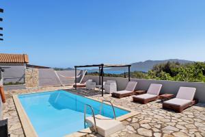 ein Schwimmbecken mit Liegestühlen und ein Schwimmbecken in der Unterkunft Villa Jimmy's Katomeri 2 in Meganisi