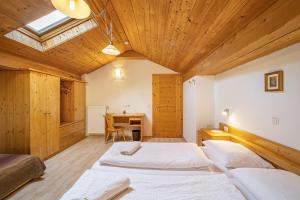 a bedroom with two beds and a desk in it at Gartnerhof Apt Sonnenblume in Colle Isarco