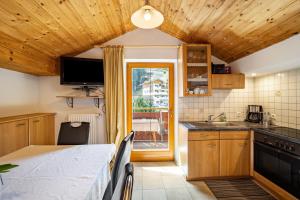 a kitchen with wooden cabinets and a table and a window at Gartnerhof Apt Sonnenblume in Colle Isarco