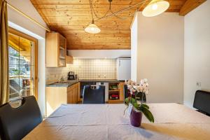 a kitchen with a table with a vase of flowers on it at Gartnerhof Apt Sonnenblume in Colle Isarco +15 photos