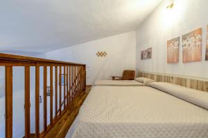 two beds in a room with a staircase at Domo Clelia in Nulvi