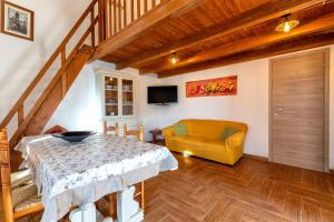 a living room with a table and a yellow chair at Domo Clelia in Nulvi