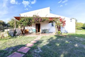 a white house with a pergola with flowers on it at Domo Clelia in Nulvi