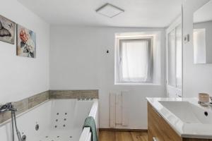 a white bathroom with a tub and a sink at Gite Cocon et Balnéo in Selles-sur-Cher +16 photos
