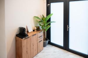 a room with a coffee maker and a plant on a wooden cabinet at Oltremare in Molfetta