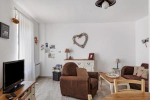 a living room with a couch and a tv at Gite Cocon et Balnéo in Selles-sur-Cher