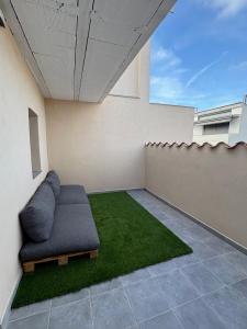 ein Wohnzimmer mit Sofa und grünem Rasen in der Unterkunft Cal Brigida in San Martín de Tous