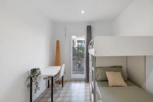 ein kleines Zimmer mit einem Bett, einem Schreibtisch und einem Tisch in der Unterkunft Cal Brigida in San Martín de Tous