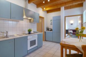 a kitchen with blue cabinets and a dining room at Ferienwohnungen Böhme in Konstanz