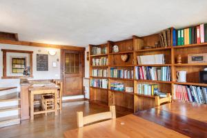 a library with wooden shelves filled with books at Agriturismo Les Ecureuils in Saint-Pierre