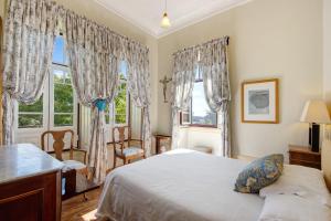 a bedroom with a bed and two windows at Guest House Casa S Martinho in Oliveira de Azemeis