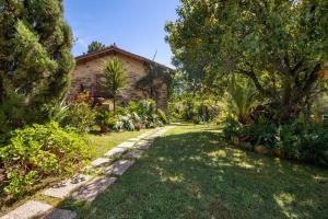 a garden with a house and trees and a path at Guest House Casa S Martinho in Oliveira de Azemeis