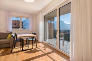 a living room with a table and chairs and a balcony at Ferienwohnungen Karin - Golden in Termeno