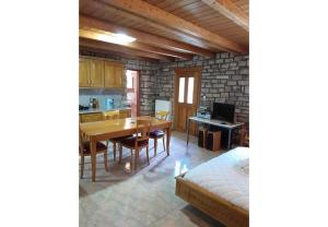 a kitchen and dining room with a table and a bed at Tsarouxi village 2 in Karditsa