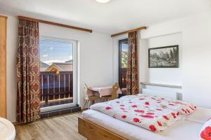 a bedroom with a bed and a large window at Pension Heidelberg in Hopfgarten im Brixental