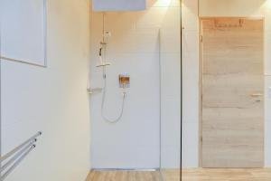 a shower with a glass door in a bathroom at Ferienwohnung Partnachklamm in Garmisch-Partenkirchen +22 photos