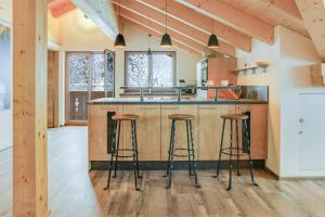 a kitchen with a center island with bar stools at Ferienwohnung Partnachklamm in Garmisch-Partenkirchen