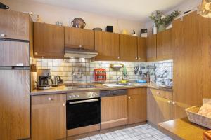 a large kitchen with wooden cabinets and appliances at Ferienwohnung Sankt Hubertus in Bad Berneck im Fichtelgebirge