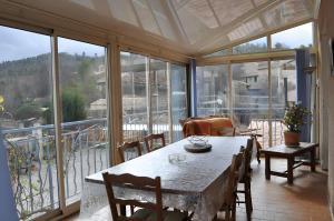 a dining room with a table and chairs and windows at Gîte Marion in Allemagne-en-Provence