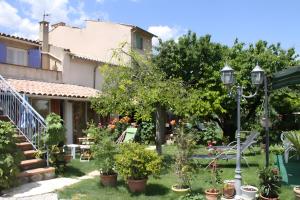 a house with a garden with potted plants at Gîte Marion in Allemagne-en-Provence