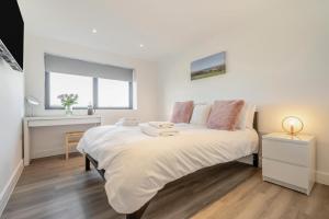 a bedroom with a large bed with white sheets and pink pillows at 2 Bed in Tintagel oc-m37507 in Tintagel