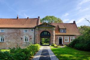 an old brick house with a large door at Ferienhaus Piet in Berumbur