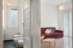 a living room with a red couch and a table at Il Mughetto in Rapallo +28 photos