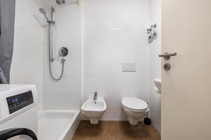 a white bathroom with a toilet and a shower at Aldars Urban Trio Suite No.6 in Munich +16 photos