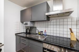 a kitchen with stainless steel cabinets and a sink at Aldars Urban Trio Suite No.6 in Munich