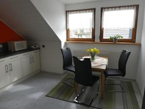 a kitchen with a table and chairs and two windows at Ferienwohnung Diepold in Wasserburg