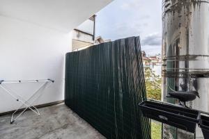 a room with a window with a green wall at Aldars Urban Trio Suite No.6 in Munich