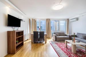 a living room with a couch and a tv at Aldars Urban Trio Suite No.6 in Munich
