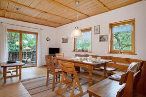 a dining room with a wooden table and chairs at Ferienhaus am Ried in Ostrach
