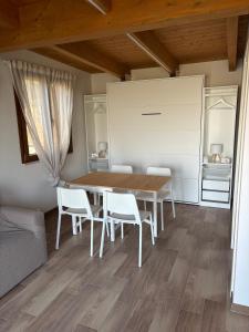 a dining room with a wooden table and white chairs at La Depandance con Giardino Pescara in Spoltore