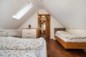 a attic bedroom with two beds and a skylight at Obst- und Ferienhof Lehle in Immenstaad am Bodensee